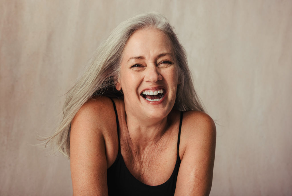 Grey haired woman celebrating her aging body.