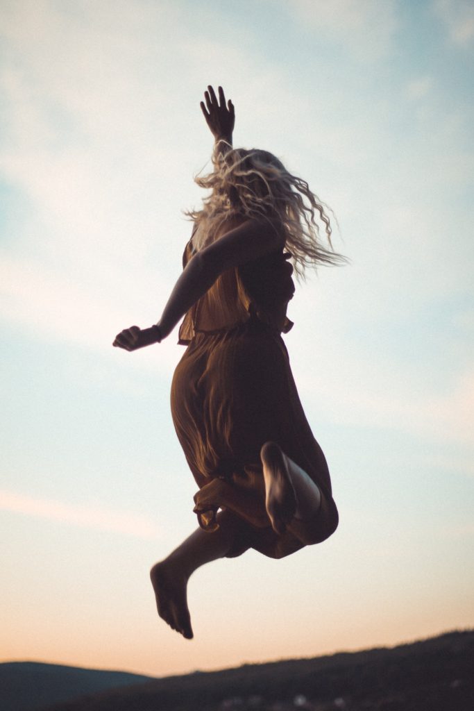 silhouette of women jumping in dress